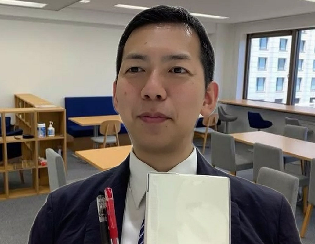 ペンとノートを持つ加藤さん